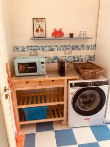 a kitchen with a microwave and a washing machine at Lungomare Crotone in Crotone