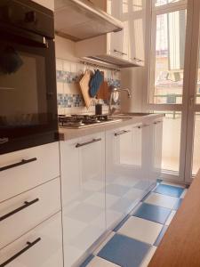 a kitchen with white cabinets and blue and white tile floors at Lungomare Crotone in Crotone