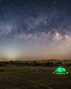 a green tent in the desert under a starry sky at Style Heritage Resort & Camp in Sām
