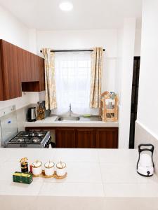 a kitchen with a white counter top and a window at Calvin's corner in Kisumu +3 photos