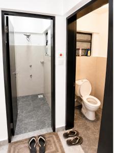 a bathroom with a toilet and a pair of shoes at Calvin's corner in Kisumu