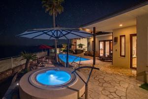 a swimming pool with an umbrella next to a house at ヴィラモンタン・淡路 in Akashi +26 photos