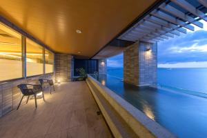 a balcony of a house with a view of the ocean at REX HOTEL Beppu in Beppu