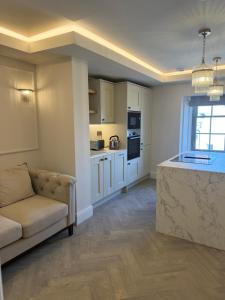 a living room with a couch and a kitchen at Oat & Olive Apartments - Alnwick in Alnwick +21 photos
