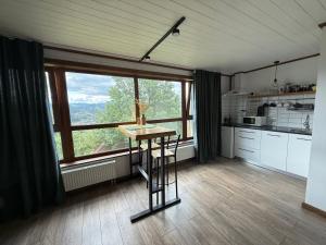 a kitchen with a table in front of a large window at fazenda slavsko in Slavske