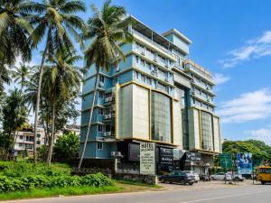 a building with palm trees in front of a street at Hotel Eagle Empire in Madgaon