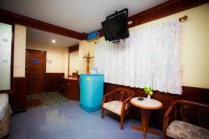a room with a small table and a television on the wall at Banna Resort in Ban Khlong Kadon (1)