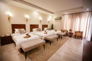 a hotel room with two beds and two tables at Alhamra Hotel in Mardan +88 photos