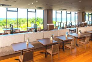 a restaurant with tables and chairs and windows at REX HOTEL Beppu in Beppu