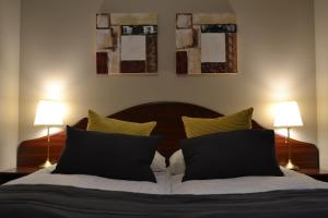 a bedroom with a bed with black and yellow pillows at Hotel Hvolsvollur - Central South Iceland in Hvolsvöllur