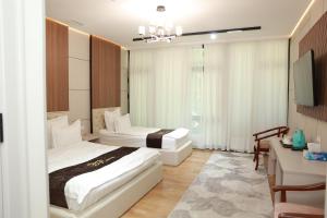 a hotel room with two beds and a television at Boulevard Palace Hotel in Samarkand