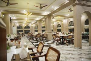 a restaurant with tables and chairs in a room at Alhamra Hotel in Mardan