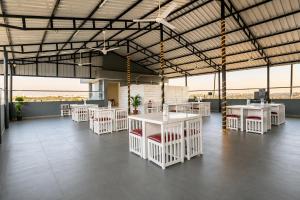 a large room with white tables and chairs at Hotel Eagle Empire in Madgaon