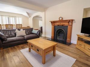 a living room with a couch and a fireplace at 4 Green Farm Cottage in Chester