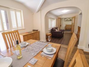 a dining room and living room with a wooden table at 4 Green Farm Cottage in Chester