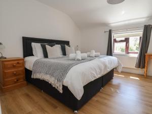 a bedroom with a bed with white sheets and a window at 4 Green Farm Cottage in Chester