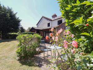 a house with a table and chairs in a garden at 4 Green Farm Cottage in Chester