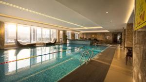 a swimming pool in a hotel with a large window at H-Vista WestGate Suites in Hanoi