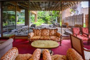 a living room with couches and a table and chairs at Nara Royal Hotel in Nara