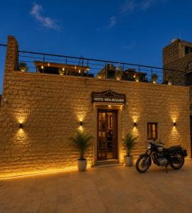 a motorcycle parked in front of a brick building at Hostel Dara Jaisalmer in Jaisalmer