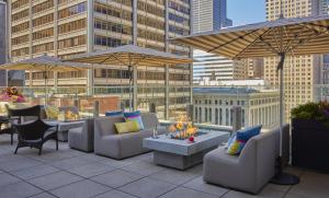 a rooftop patio with couches and tables and umbrellas at Hyatt Centric The Loop Chicago in Chicago
