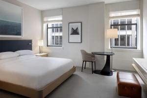 a bedroom with a bed and a table and two windows at Hyatt Centric The Loop Chicago in Chicago +57 photos