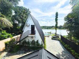 a house with a triangular roof and a staircase next to a river at Mangalath River View Resorts in Kodanad