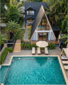 a house with a swimming pool in front of a house at Mangalath River View Resorts in Kodanad