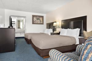 a hotel room with two beds and a chair at Quality Inn Rock Springs - Green River in Rock Springs