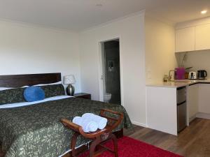 a bedroom with a bed and a small kitchen at Private Cozy Sleepout with Free Parking & Self Check-in in Hamilton +17 photos