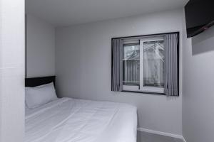 a white bedroom with a bed and a window at VIA jongno in Seoul +10 photos