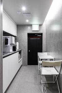 a kitchen with a black door and a table and chairs at VIA jongno in Seoul
