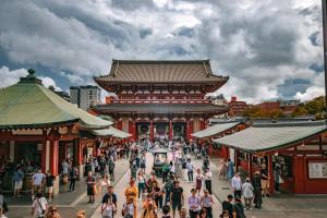 a crowd of people walking in front of a building at MKG HOTEL Asakusa in Tokyo