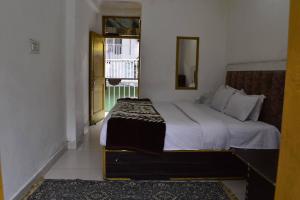 a bedroom with a bed with a mirror and a window at Sandeep homestay in Dharamshala +15 photos
