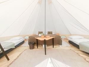 a room with two beds and a table in a tent at Venejoen Piilo - Sammal in Joensuu