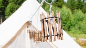 a row of wooden sticks hanging from a white tent at Venejoen Piilo - Sammal in Joensuu +7 photos