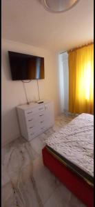 a bedroom with a bed and a dresser with a tv at Ibo in Brăila +3 photos