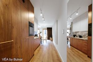 a kitchen with wooden cabinets and a dining room at VÉA by Bulvar in Kielce