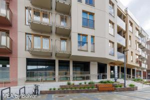 an apartment building with a bench in front of it at VÉA by Bulvar in Kielce