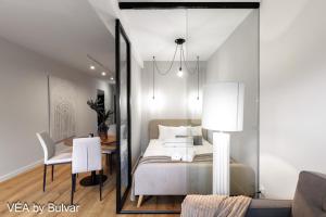 a bedroom with a bed and a dining room at VÉA by Bulvar in Kielce