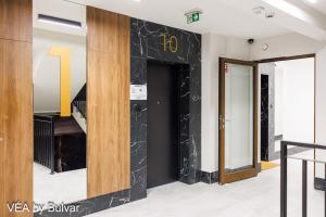 a hallway with a black marble wall in a building at VÉA by Bulvar in Kielce