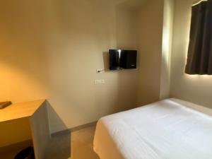 ein kleines Schlafzimmer mit Bett und Schreibtisch in der Unterkunft Hotel Miralite in Tinsukia + 29 Fotos
