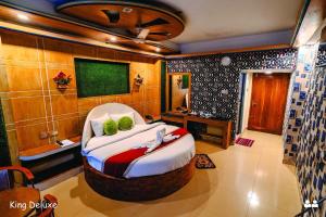 a bedroom with a large bed with a tv on the wall at Hotel Oasis International in Cox's Bazar