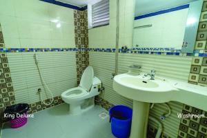 a bathroom with a toilet and a sink at Hotel Oasis International in Cox's Bazar