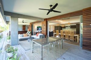 a dining room and living room with a ceiling fan at Manta Cove by Blue Zebra Holidays in Rivière Noire