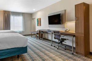 a hotel room with a bed and a desk and a television at MainStay Suites Carlsbad South in Carlsbad
