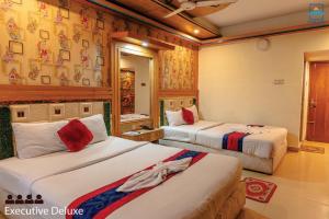 a hotel room with two beds in a room at Hotel Oasis International in Cox's Bazar