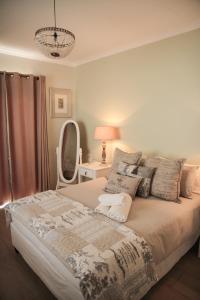 ein Schlafzimmer mit einem Bett mit einer Lampe und einem Spiegel in der Unterkunft Olive Manor Guest House in Newcastle