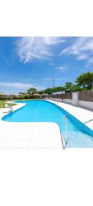 a large swimming pool with blue water at Adhara lll in Torre del Mar