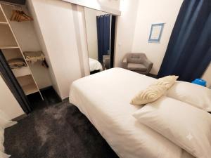 a bedroom with a white bed and a chair at Notre bout du monde t1bis brest centre terrasse in Brest